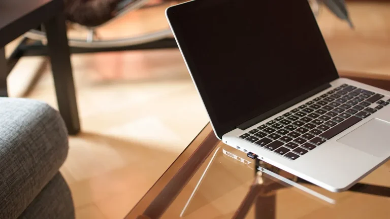 Laptop z projektem mebli 3D oraz rysunki techniczne szafy na biurku