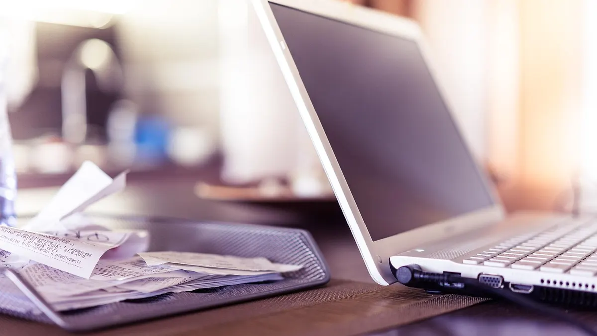 Laptop na biurku z dokumentami firmowymi do współdzielenia plików