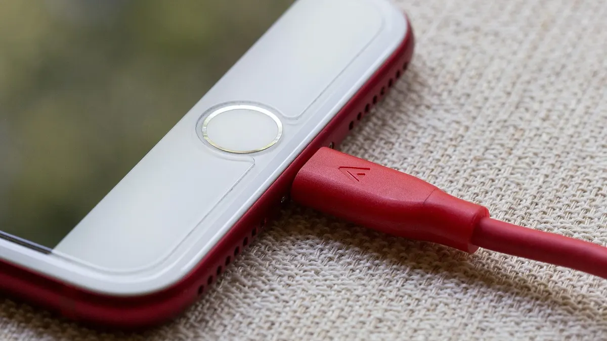 iPhone podłączony przewodem do komputera podczas przywracania systemu