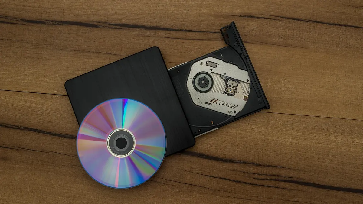 Zewnętrzna nagrywarka CD USB z pustą płytą obok laptopa