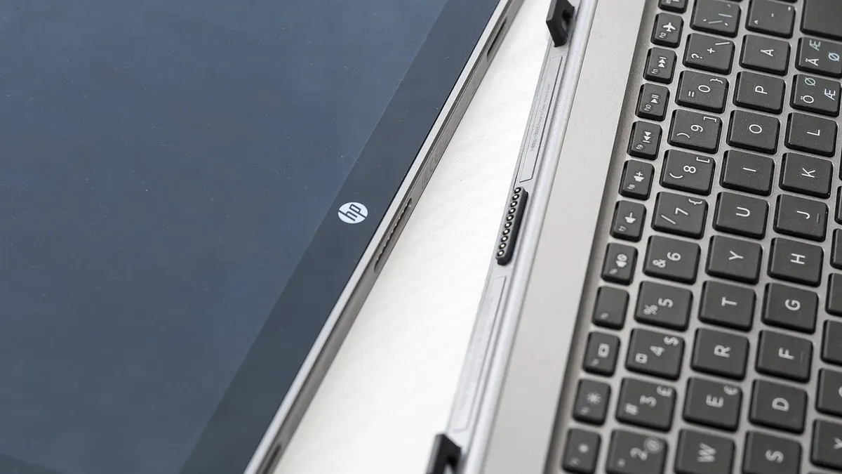 Laptop z otwartym załącznikiem e-mail i plikami do sprawdzenia