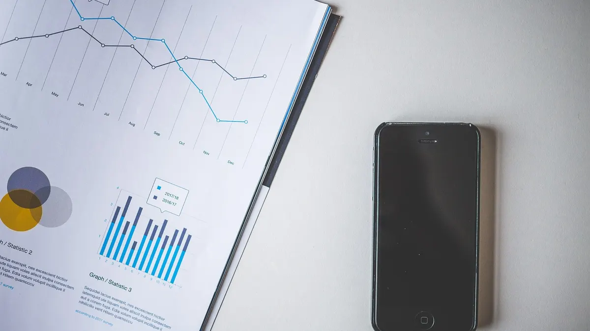 Smartfon obok otwartego dokumentu tekstowego na biurku