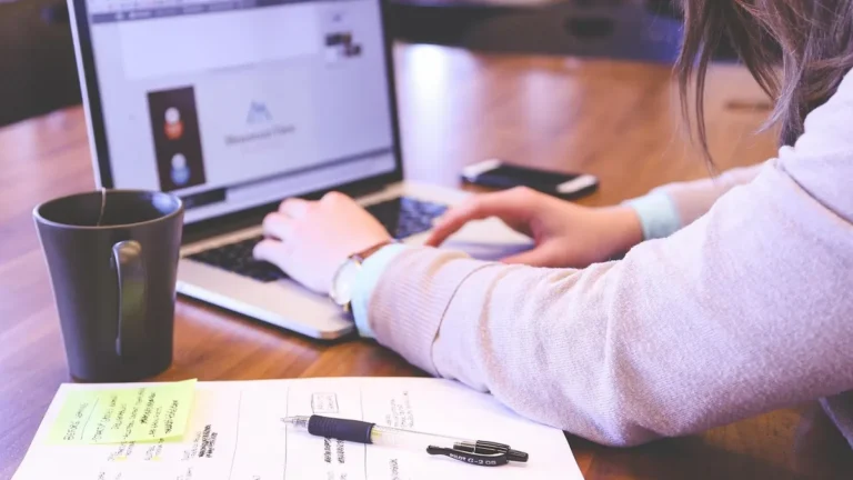 Laptop z otwartą prezentacją na ekranie obok projektora