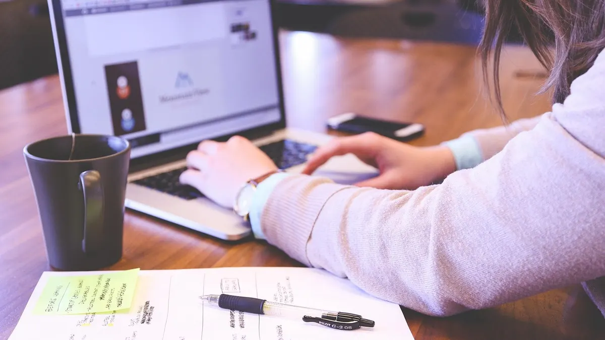 Laptop z otwartą prezentacją na ekranie obok projektora