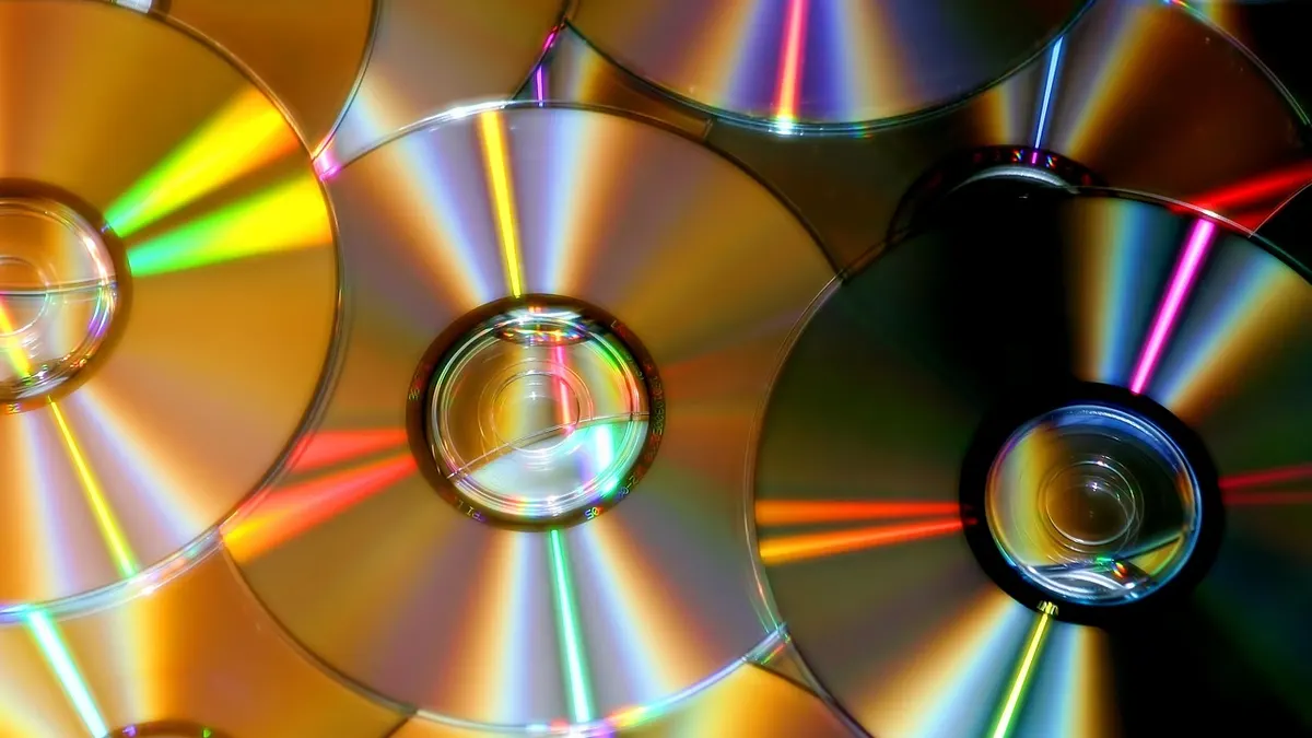 Laptop ze słuchawkami i płytą CD do legalnego zgrywania muzyki