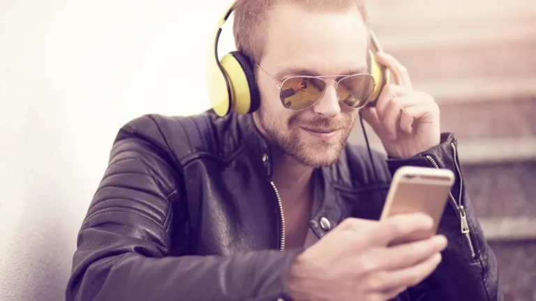 Smartfon ze słuchawkami podczas słuchania muzyki z aplikacji