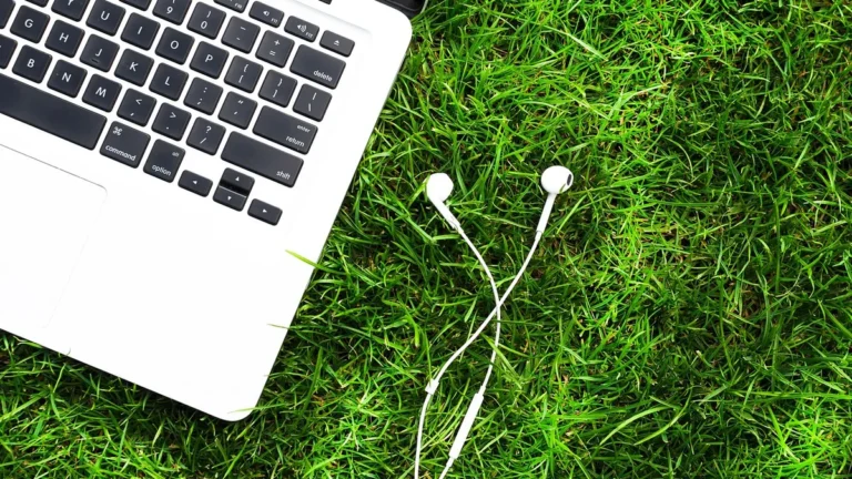 Laptop z włączonym Bluetooth i bezprzewodowymi słuchawkami na biurku