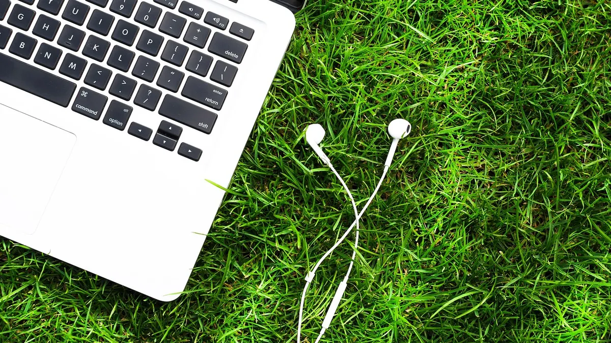 Laptop z włączonym Bluetooth i bezprzewodowymi słuchawkami na biurku