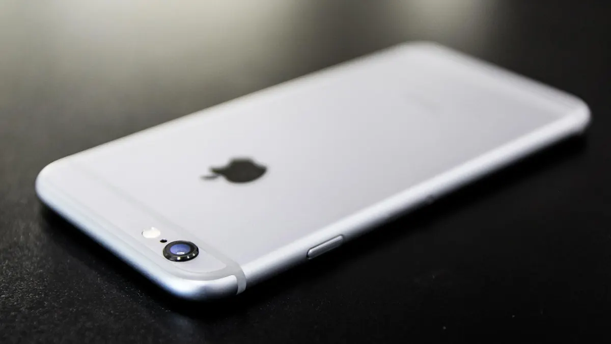 iPhone z otwartą aplikacją Wiadomości i ustawieniami sieci komórkowej