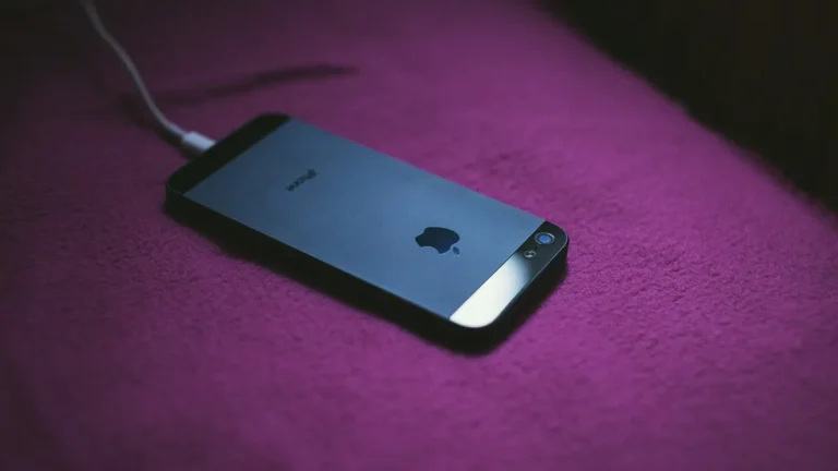 iPhone leżący na bezprzewodowej ładowarce indukcyjnej MagSafe