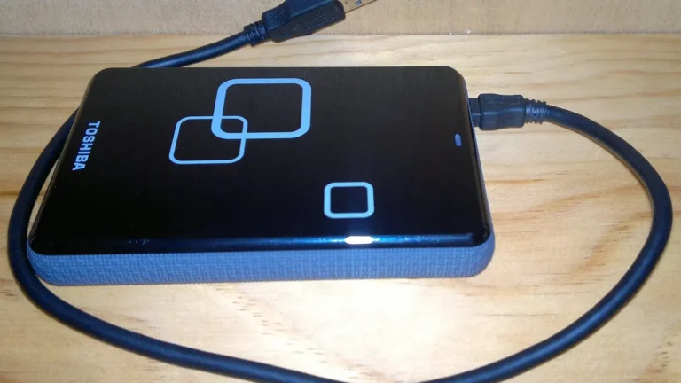 Laptop z dyskiem zewnętrznym podczas porządkowania plików i tworzenia kopii zapasowej