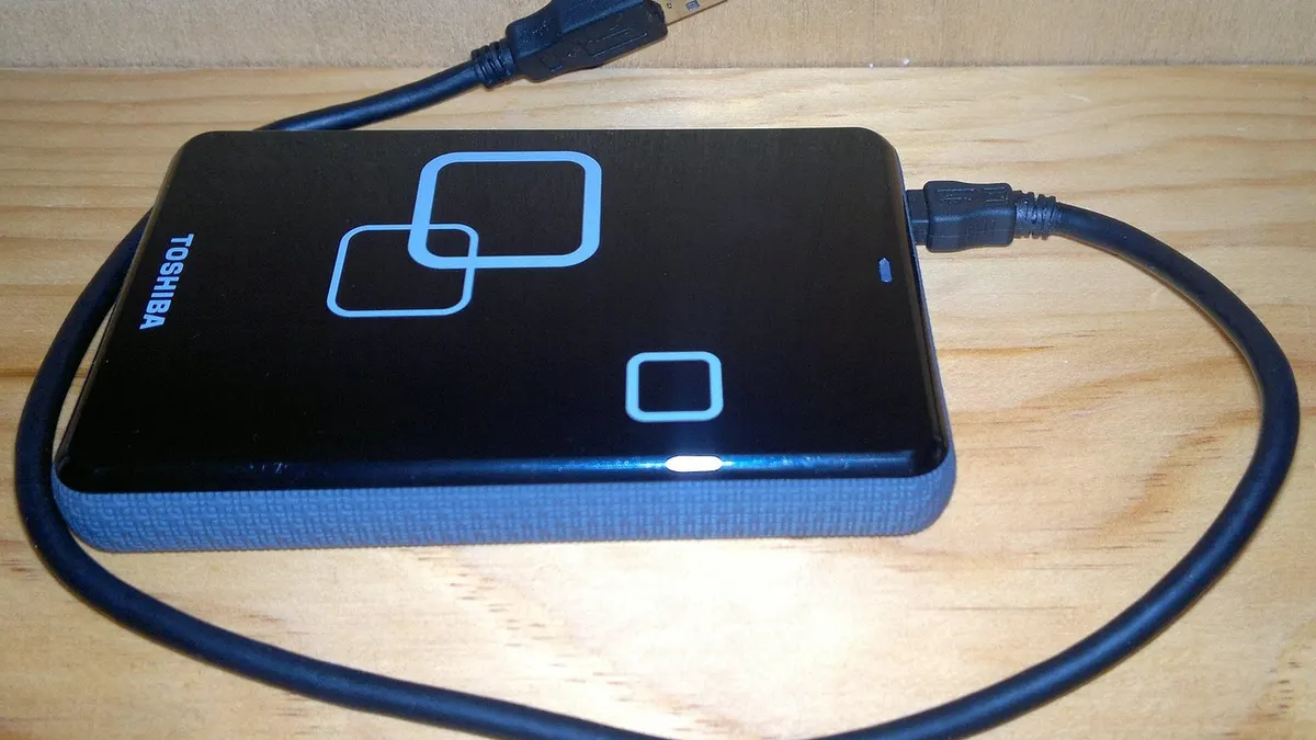 Laptop z dyskiem zewnętrznym podczas porządkowania plików i tworzenia kopii zapasowej