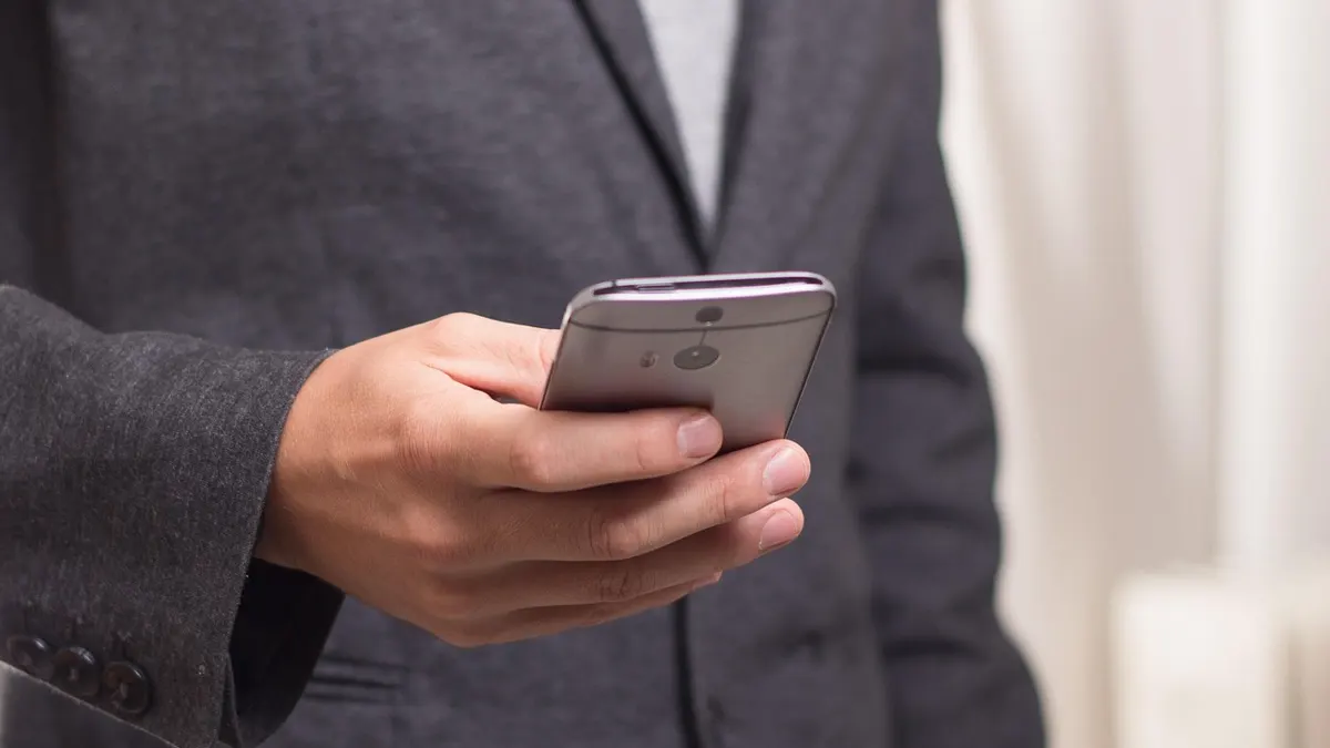 Smartfon z otwartą klawiaturą ekranową podczas wpisywania tekstu