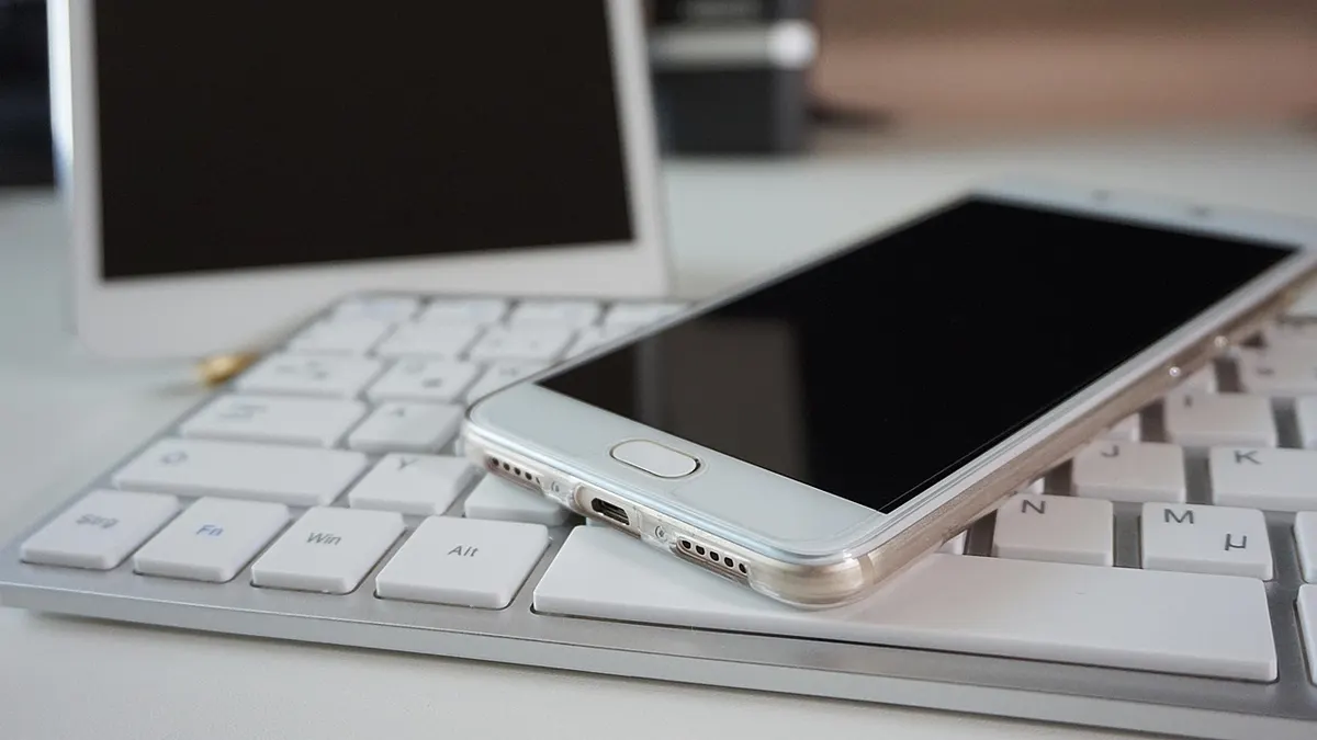 Smartfon z otwartą klawiaturą ekranową podczas pisania wiadomości