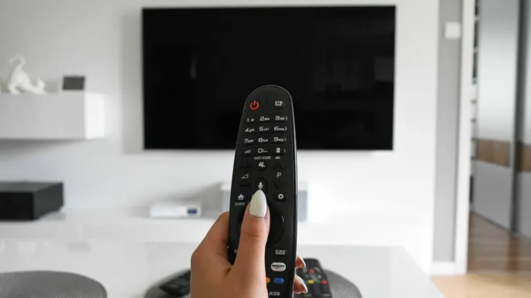 Pilot obok telewizora Smart TV z widocznym ekranem ustawień aplikacji