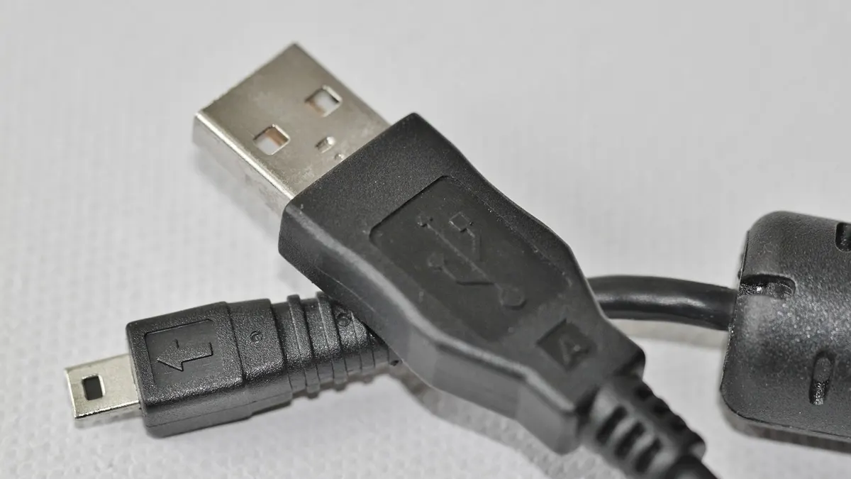 Aparat cyfrowy podłączony kablem USB do laptopa podczas kopiowania zdjęć