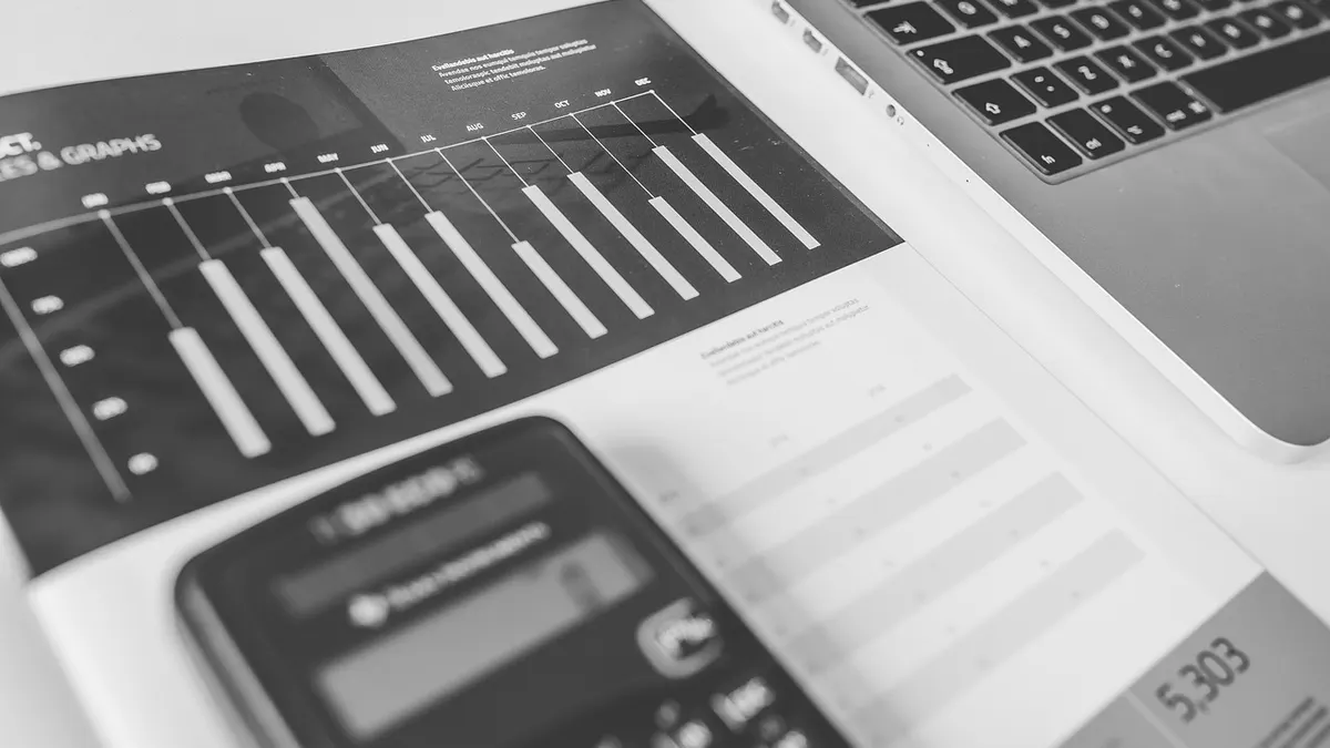 Laptop z dokumentami papierowymi przygotowanymi do zapisu w formacie PDF
