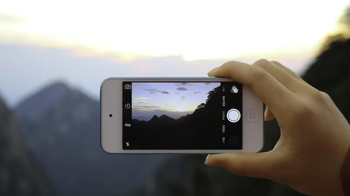 iPhone podłączony do laptopa podczas przenoszenia zdjęć do formatu JPG
