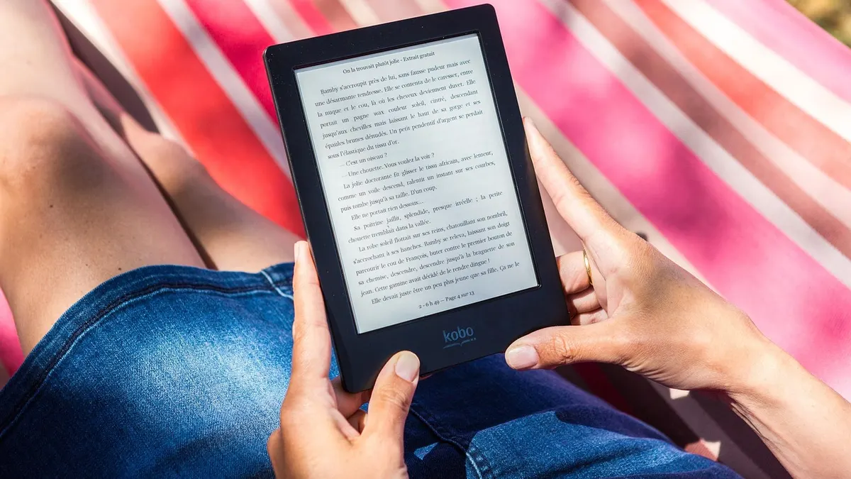 Czytnik e-booków obok laptopa z otwartą biblioteką cyfrową