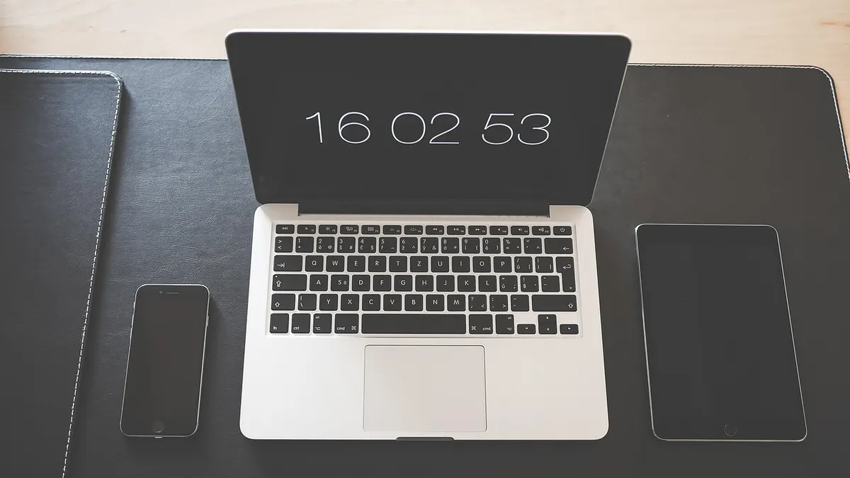 iPhone i MacBook na biurku przygotowane do tworzenia kopii zapasowej w iCloud