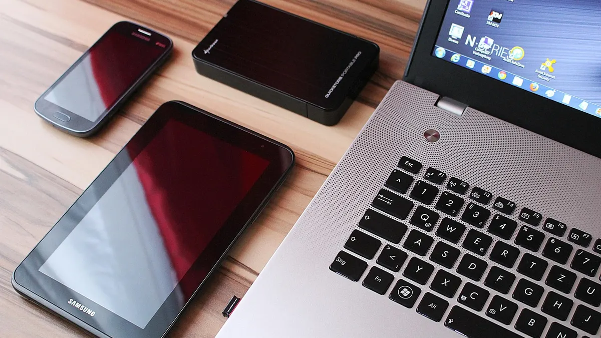 Laptop z dokumentami i dyskiem zewnętrznym na biurku